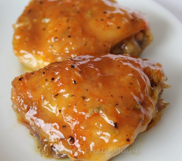 two pieces of chicken covered in sauce on a white plate