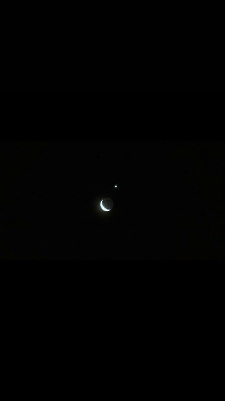 the moon is seen in the dark sky