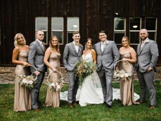 a group of people standing next to each other in front of a wooden building with windows