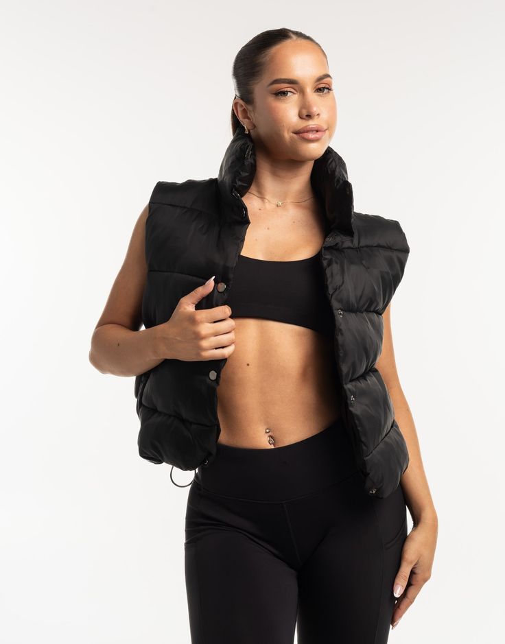 a woman in black sports bra and padded vest