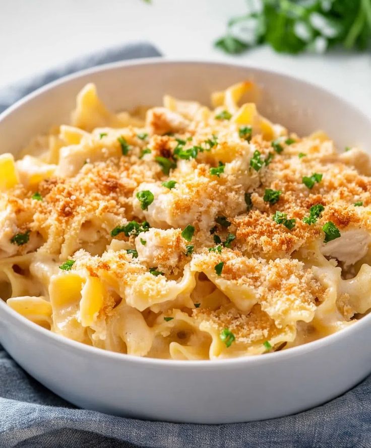 a white bowl filled with macaroni and cheese on top of a blue towel