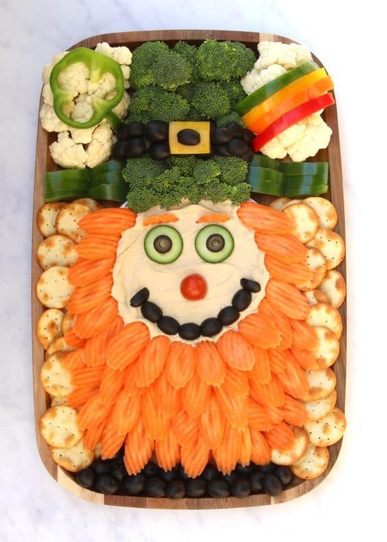 a platter with vegetables, cauliflower, broccoli and a face made to look like a lion