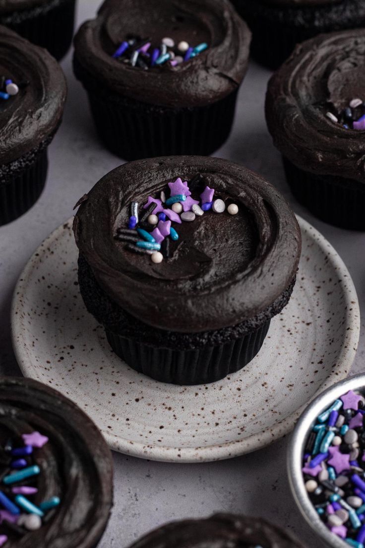 cupcakes with chocolate frosting and sprinkles on plates