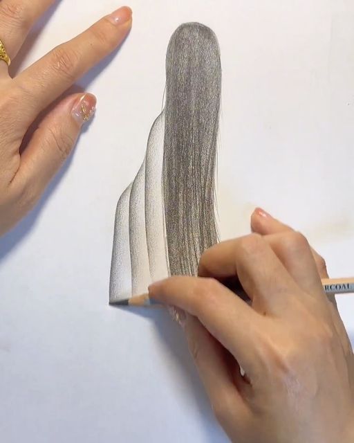 someone is drawing something with colored pencils on the paper and it looks like they have long hair