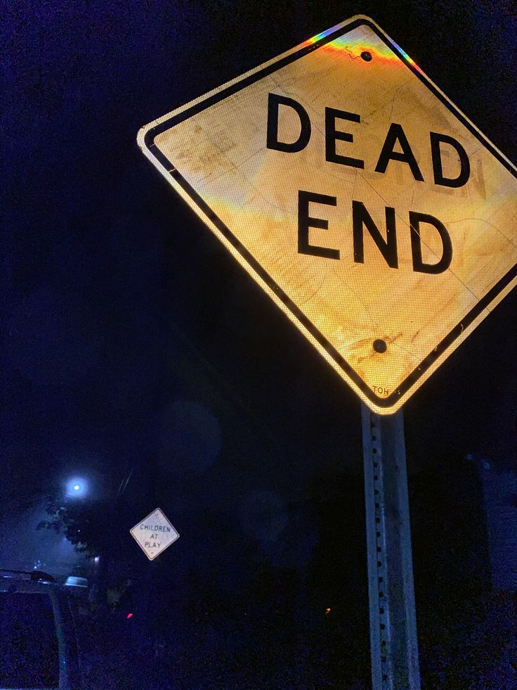 a yellow dead end sign sitting on the side of a road