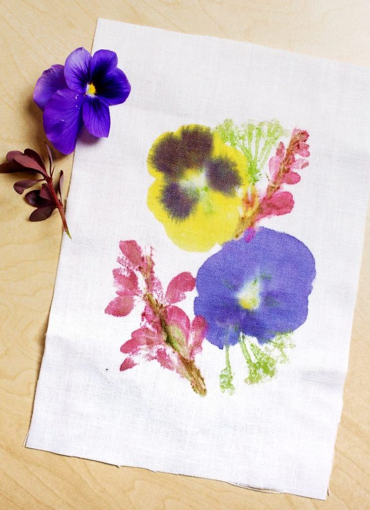 a flower is sitting on top of a piece of paper that has been embroidered onto it