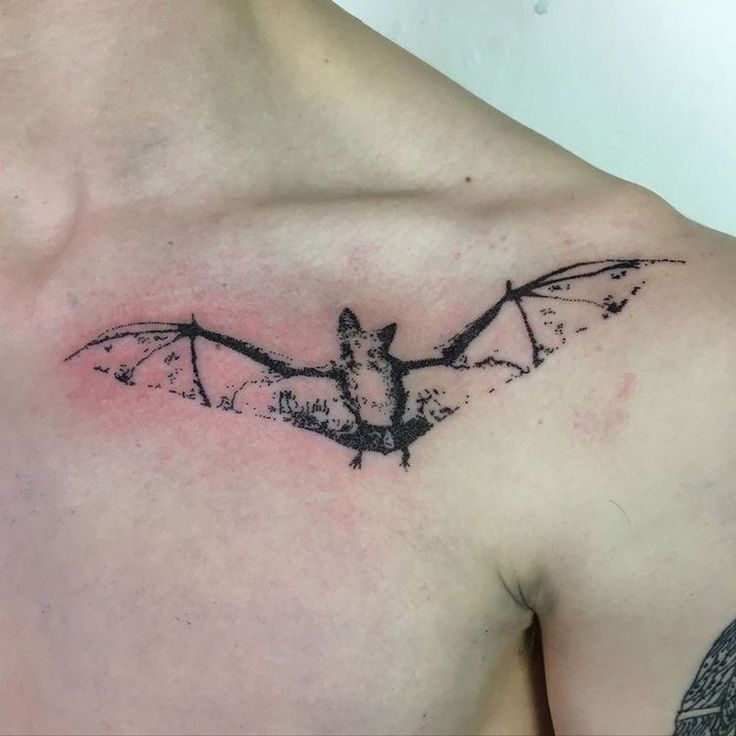 a man with a bat tattoo on his chest