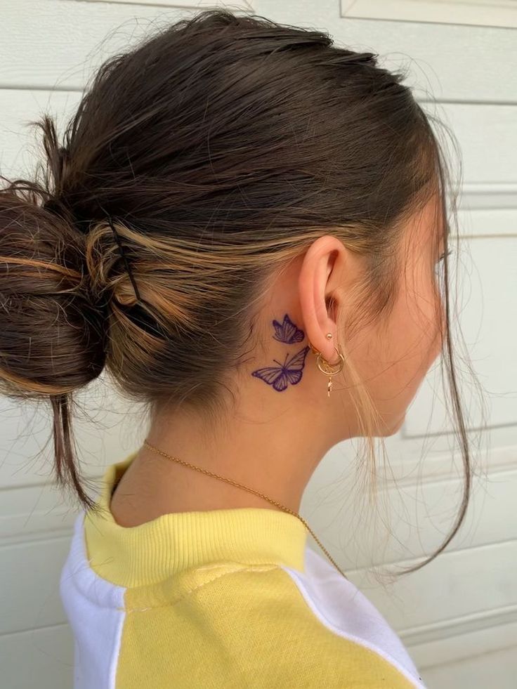 a woman with a flower tattoo on her left side of her neck and behind her ear