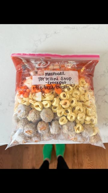 a bag of macaroni and cheese balls on top of a wooden floor next to a person's feet