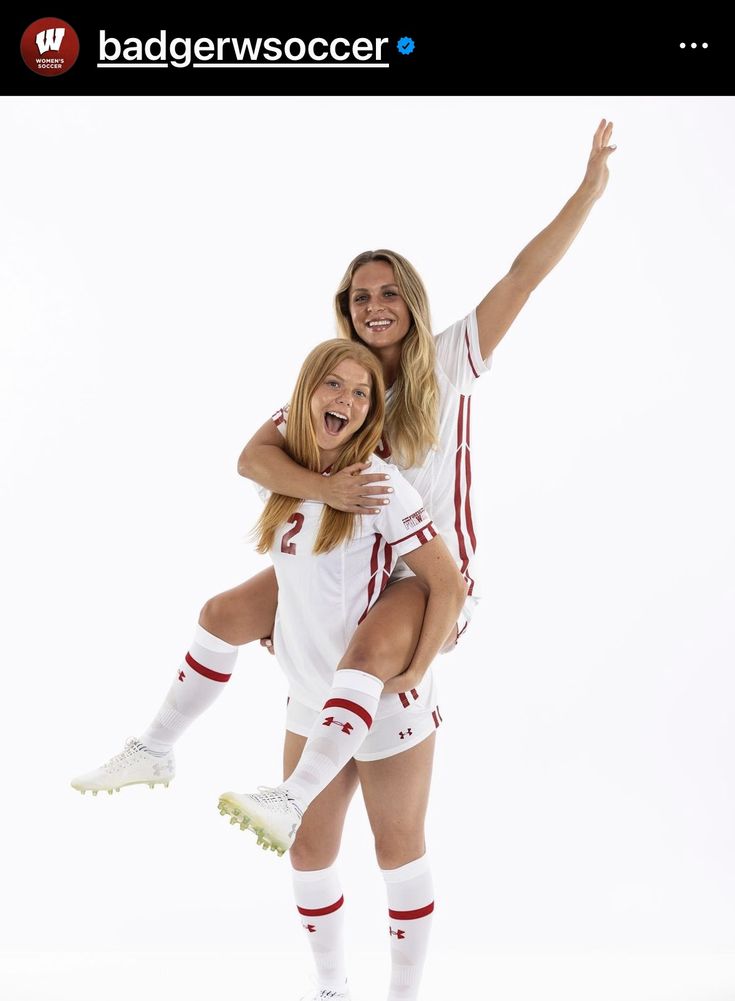 two women in white soccer uniforms are posing for the camera with their arms around each other