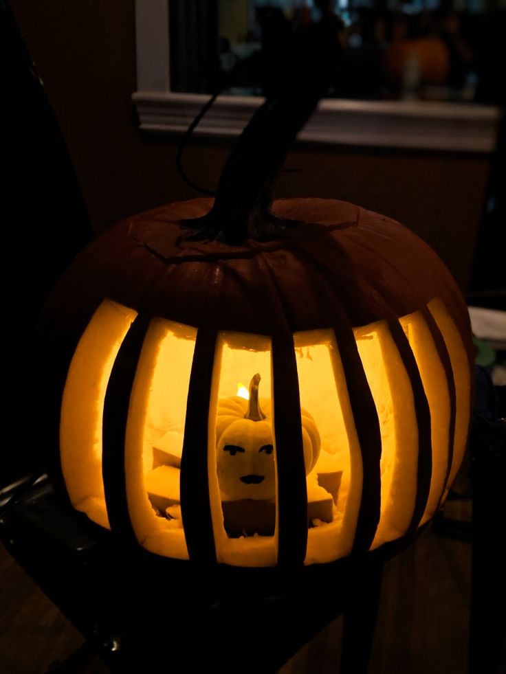 a pumpkin carved to look like a cat with stripes on it's face and eyes