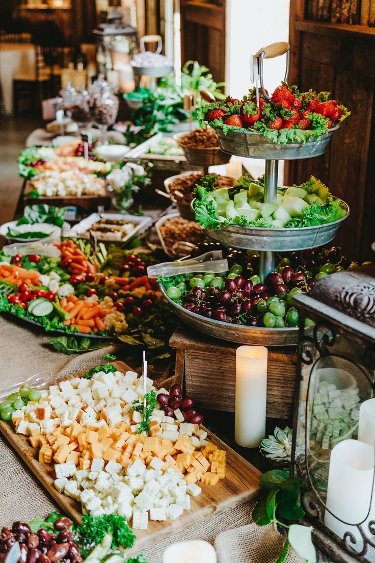 a buffet table filled with lots of different types of food and candles on top of it