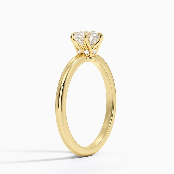 a yellow gold engagement ring with two diamonds on the top and bottom, against a white background