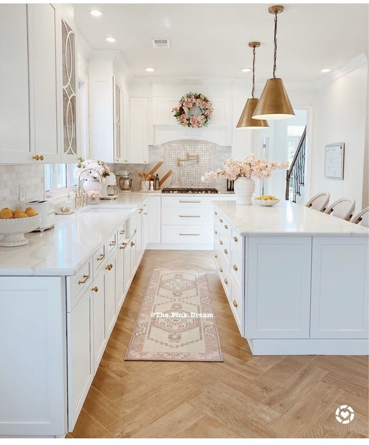 a large kitchen with white cabinets and gold accents on the ceiling, along with an area rug