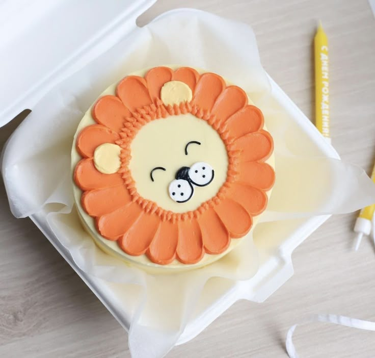 a decorated cake in the shape of a lion's head with eyes and nose