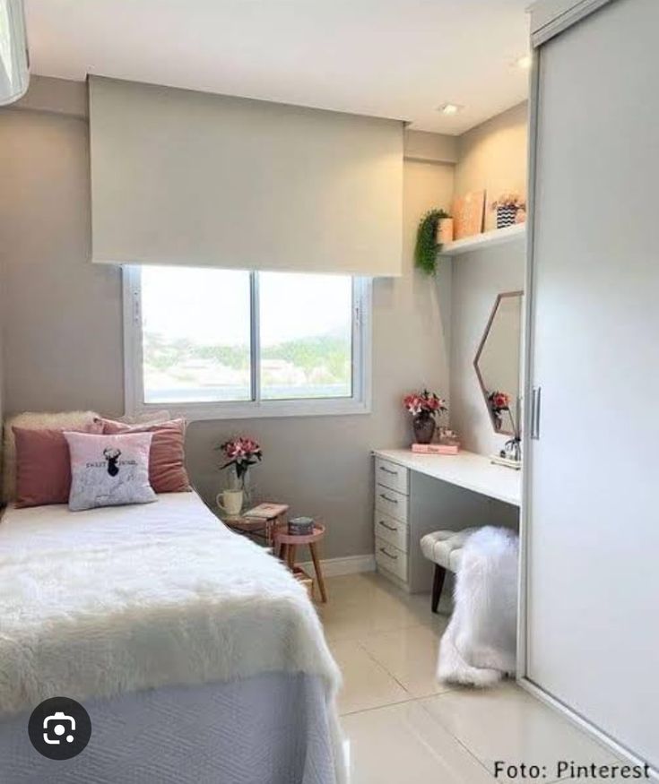 a bedroom with a bed, desk and dresser in it's corner area next to a window