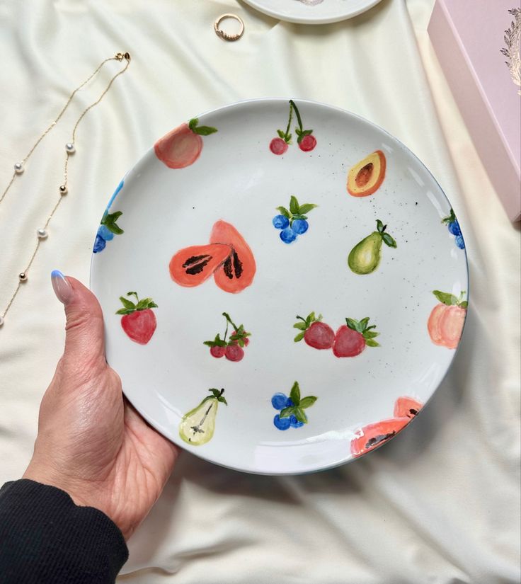 a person holding a plate with fruit on it