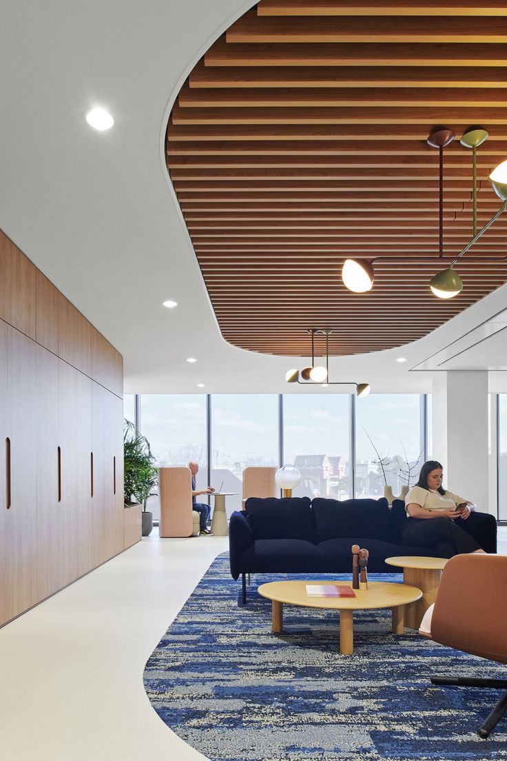 a woman sitting on a blue couch in an office