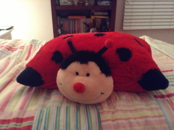 a ladybug stuffed animal laying on top of a bed