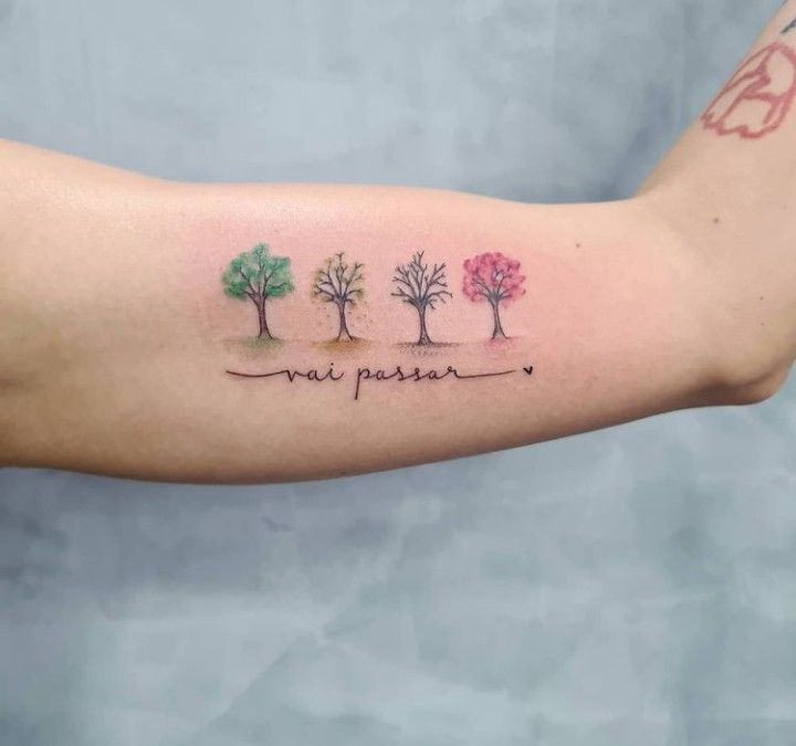 a woman's arm with three trees and the words happy new year written on it