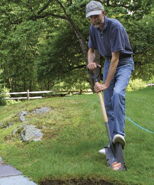 a man is digging in the ground with a shovel