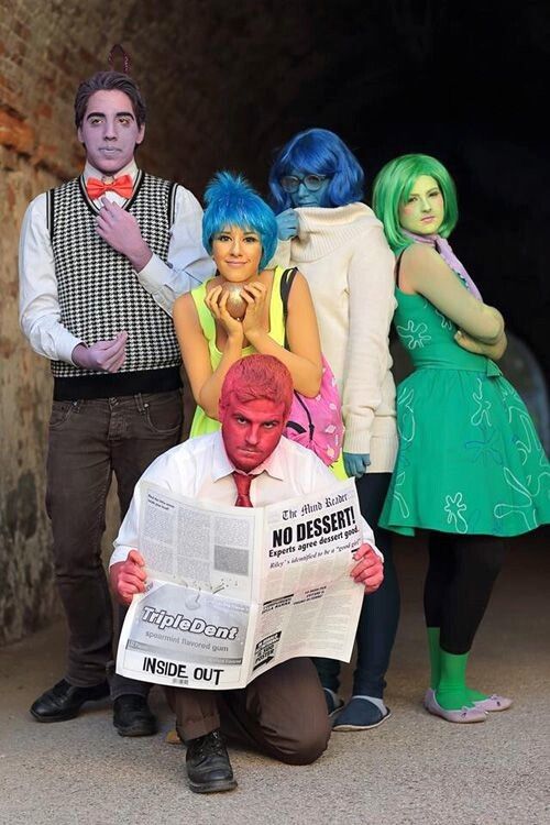 three people dressed in costumes standing next to each other and one holding a news paper