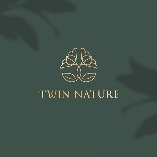 the logo for twin nature is shown on a green background with leaves and branches in gold