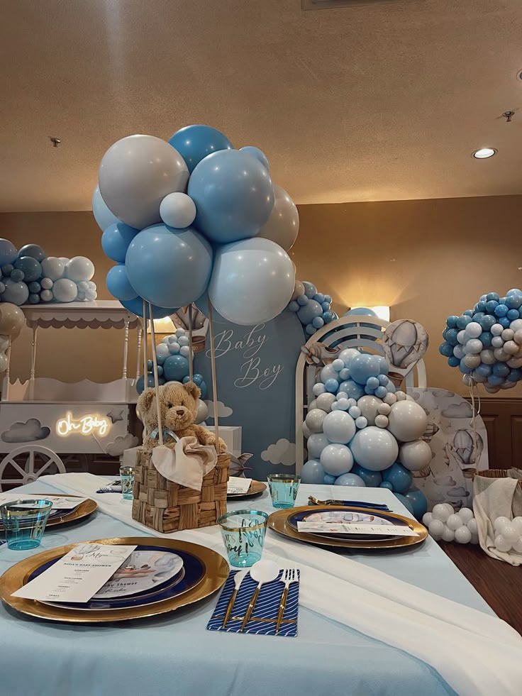 blue and white balloons are on display at a baby's first birthday party table