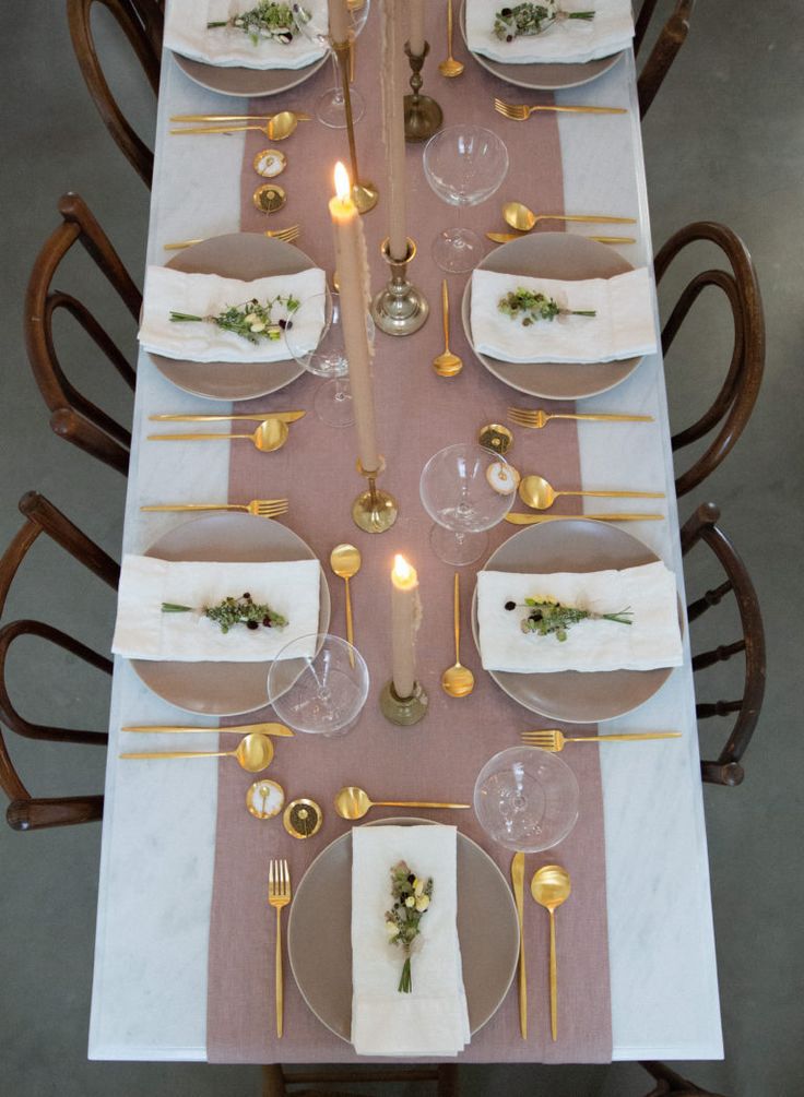 the table is set with plates, silverware and napkins for an elegant dinner