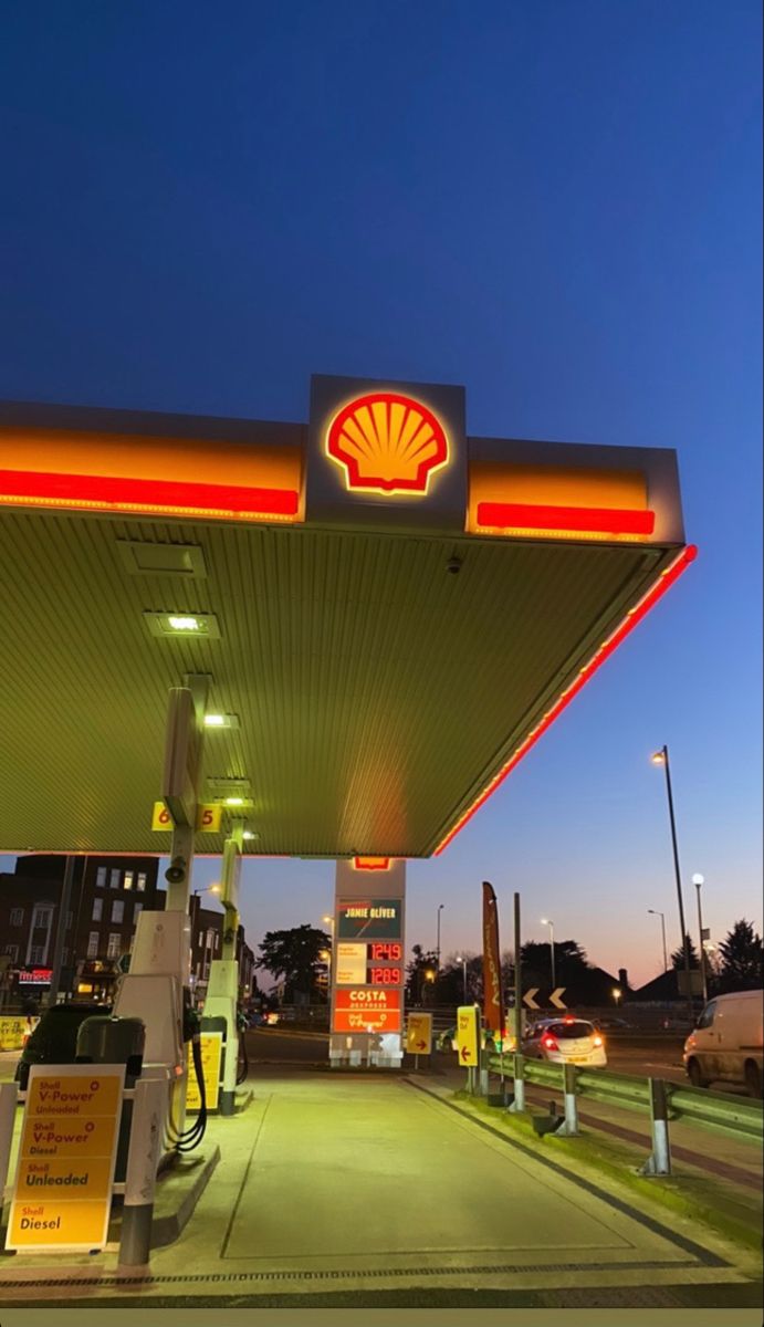 a shell gas station at night with the lights on