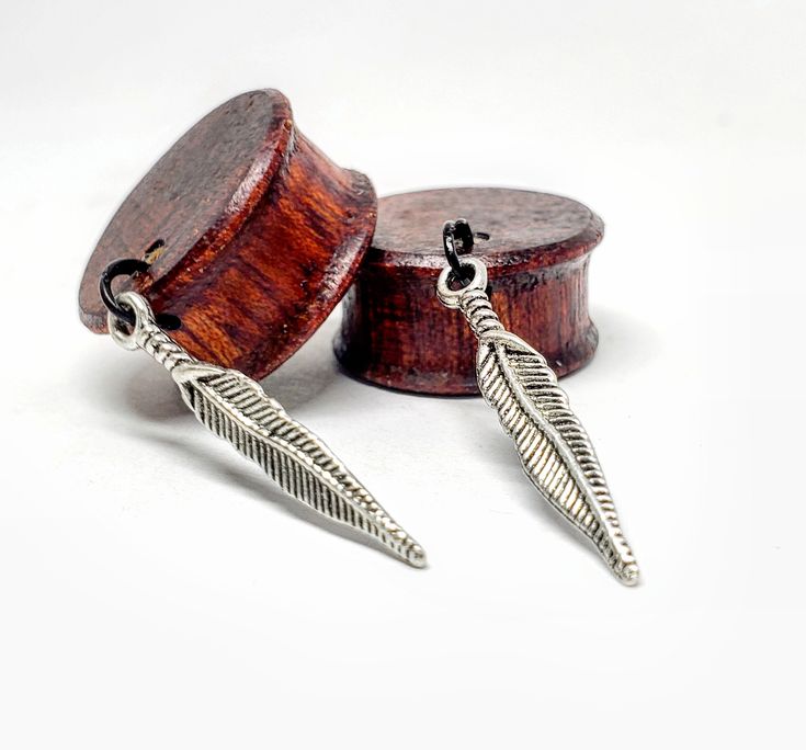 "1 SET OF Whispering Feathers on Bloodwood  Plugs (Plugs in Ear shot photo are 3/4\"(19mm)  Our Commitment to Giving Back: BUY ONE,PLANT ONE-  As if getting Eco-friendly amazing Organic Wooden Plugs & Tunnels were not enough, you can sleep easy knowing that a tree was planted with your purchase. This is something that means a lot to us, and was one of the motivating factors that led us to create this company! The charity that we are partnered up with is www.Plantabillion.org ! Size available:  2g(6mm) Og(8mm) 00g(10mm) 7/16\"(11mm) 1/2\"(13mm) 9/16\"(14mm) 5/8\"(16mm) 11/16\"(17.5mm) 3/4\"(19mm) 7/8\"(22mm)  1\"(25mm) Each Bloodwood plug earring is carefully hand shaped to a proper fitting size. Jojoba oil is then massaged into the wood with a finishing coat of organic plant-based wax to p Plug Earrings Gauges, Gauge Sizes, Dangle Plugs, Wooden Plugs, Gauge Earrings, Wood Plugs, Plug Earrings, Tunnels And Plugs, Gauged Earrings