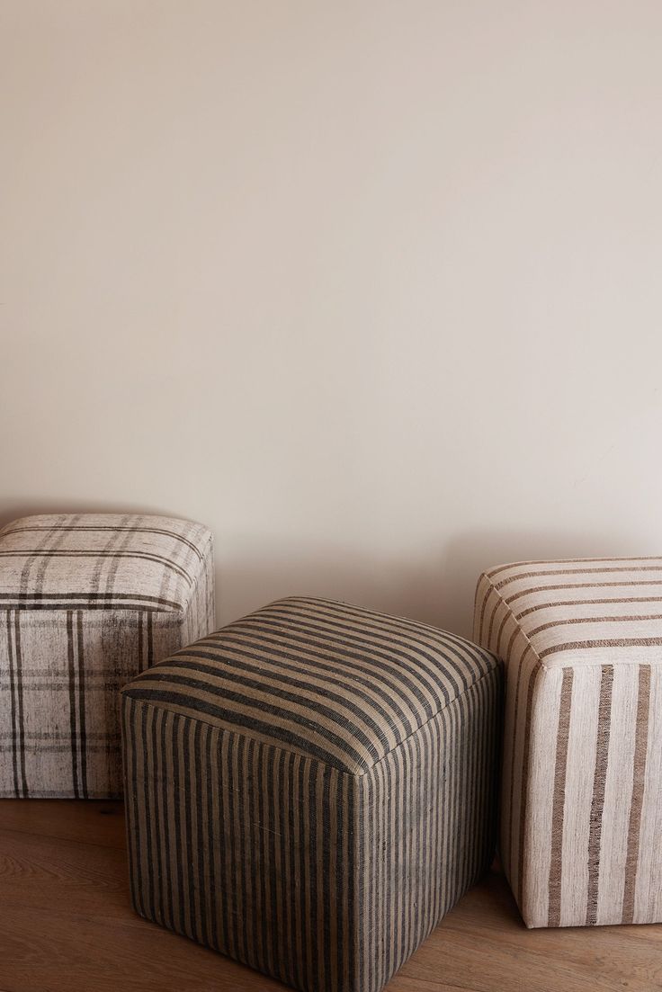 three small stools sitting next to each other on a wooden floor