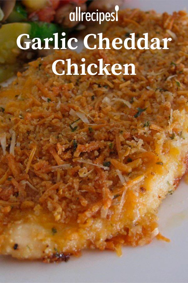 a white plate topped with chicken covered in grated cheese