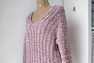 a pink sweater hanging on a white wall next to a mannequin's head