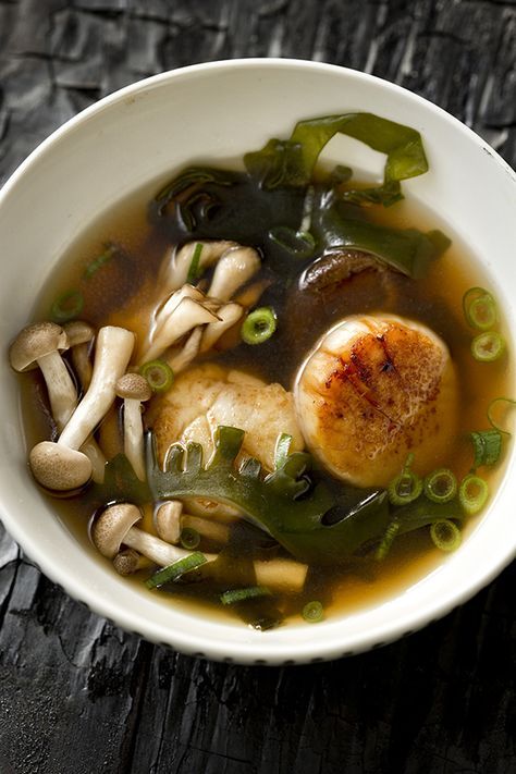 a white bowl filled with soup on top of a wooden table