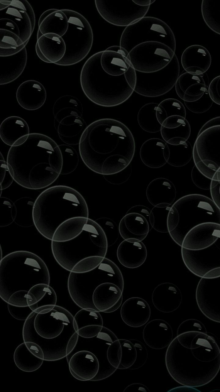 soap bubbles floating in the air on a black background