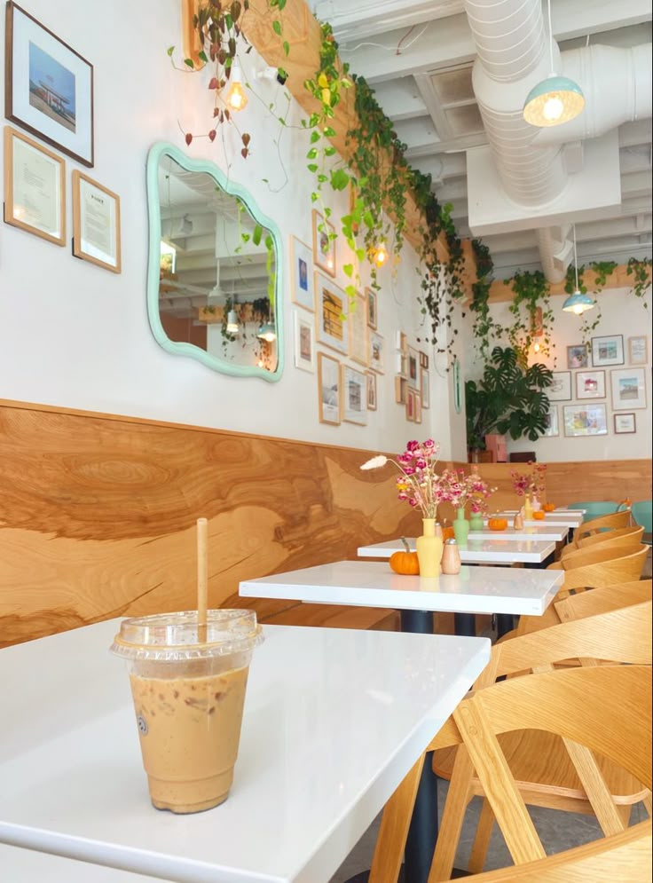 the interior of a restaurant with tables, chairs and pictures on the wall above them