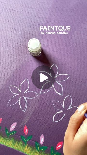 someone is drawing flowers on a piece of purple paper with white paint and a marker