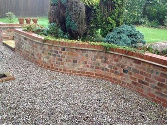 a brick retaining wall in the middle of a garden