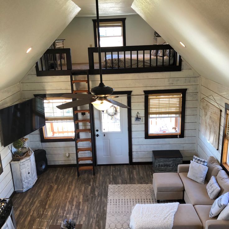 a living room filled with furniture and a ceiling fan