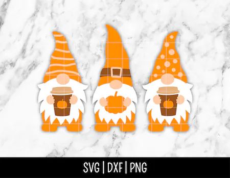 three gnomes with orange hats and beards are sitting on a marble counter top