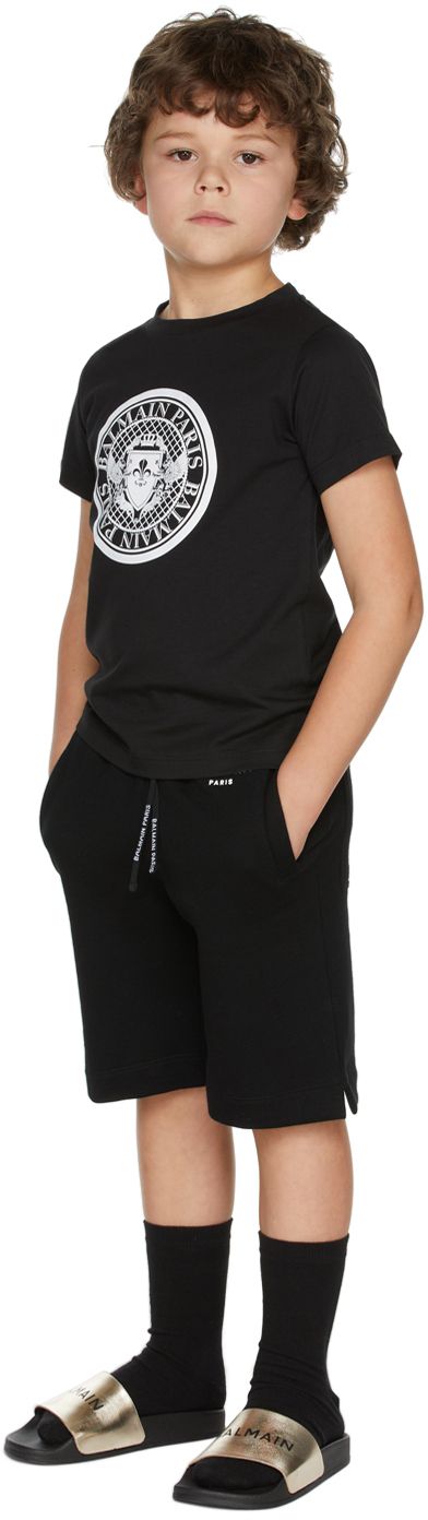 French terry shorts in black. Logo printed in white at front waist and back pocket. · Mid-rise · Four-pocket styling · Drawstring at elasticized waistband · Vented outseams · Machine wash Model measures 49 / 124.5 cm tall and wears size 6. Supplier color: Black Size: child's height 4: 40.9 / 104 cm 6: 45.7 / 116 cm 8: 50.4 / 128 cm 10: 55.1 / 140 cm 12: 59.8 / 152 cm 14: 62.2 / 158 cm | Balmain Kids Black Small Logo Shorts French Terry Shorts, Terry Shorts, Black Logo, Back Pocket, French Terry, Tshirt Dress, Apparel Accessories, Mid Rise, Shirt Dress