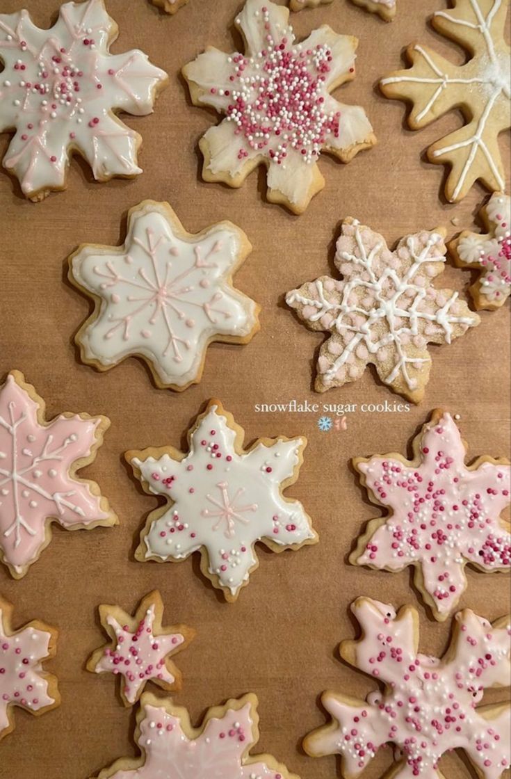 decorated sugar cookies on a baking sheet with sprinkles and snowflakes