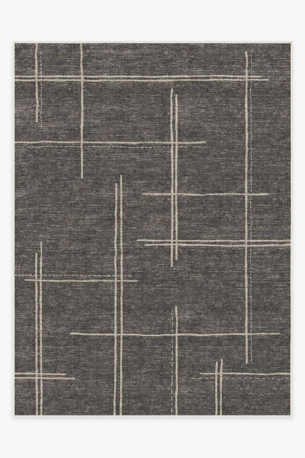 a gray rug with white lines on the top and bottom, in an abstract pattern