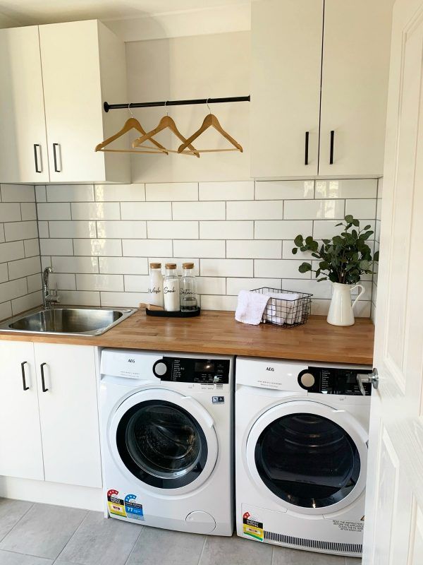 a washer and dryer sitting in a kitchen next to each other on top of a wooden counter