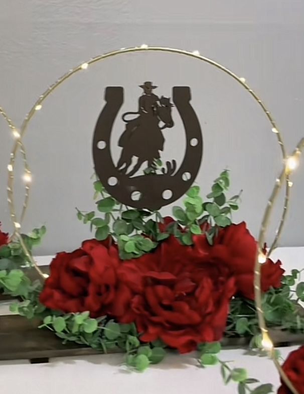 a horseshoe with roses and lights around it on top of a white tablecloth covered table