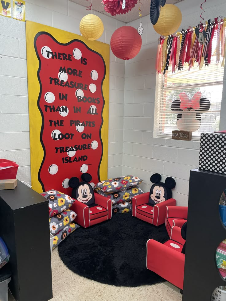 a room with mickey mouse decorations and red chairs