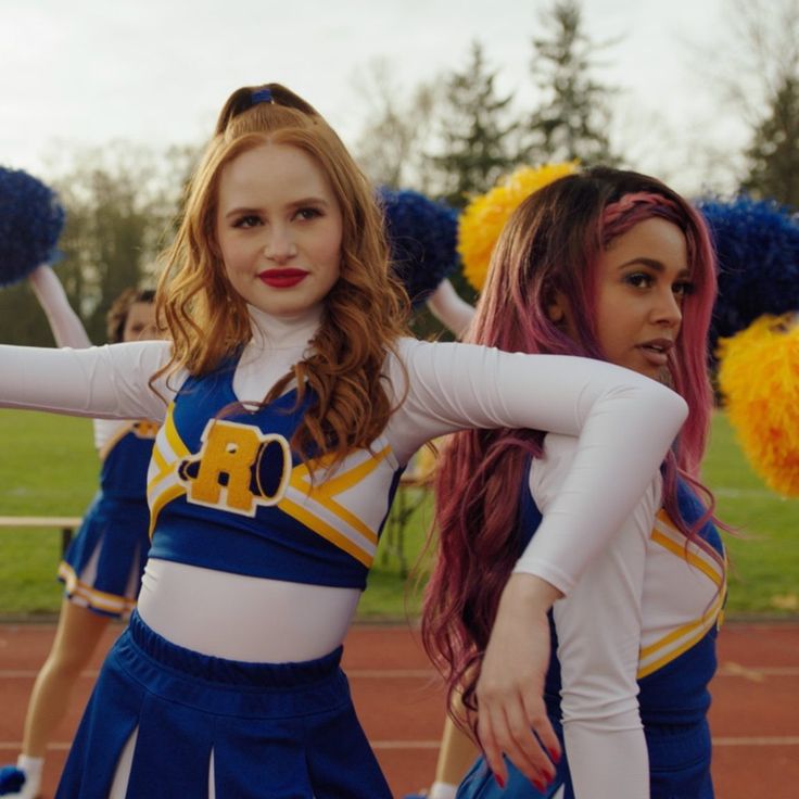 two cheerleaders in blue and yellow outfits