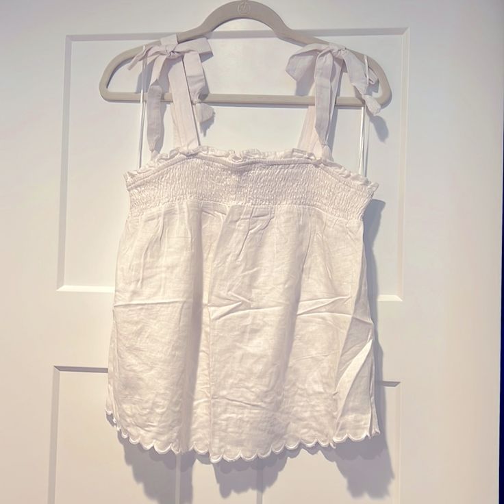 White Babydoll Camisole. Straps Tie At Top With Cute Fringe Detail. Scalloped Hem. Nwt. Never Worn. Perfect Condition. Cute Ruffled Camisole Tank Top, Cotton Tank Top With Adjustable Ruffled Straps, Cute Sleeveless Top With Lace Trim, Beach Cotton Tops With Ruffled Straps, Cute Sleeveless Lace Trim Tops, Cute Ruffled Tank Top, Cotton Tops With Ruffled Straps For Beach, Cute Cotton Sleeveless Camisole, Cotton Sleeveless Tank Top With Tie Straps