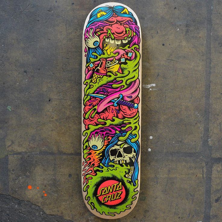 a skateboard that is sitting on the ground with graffiti all over it's surface